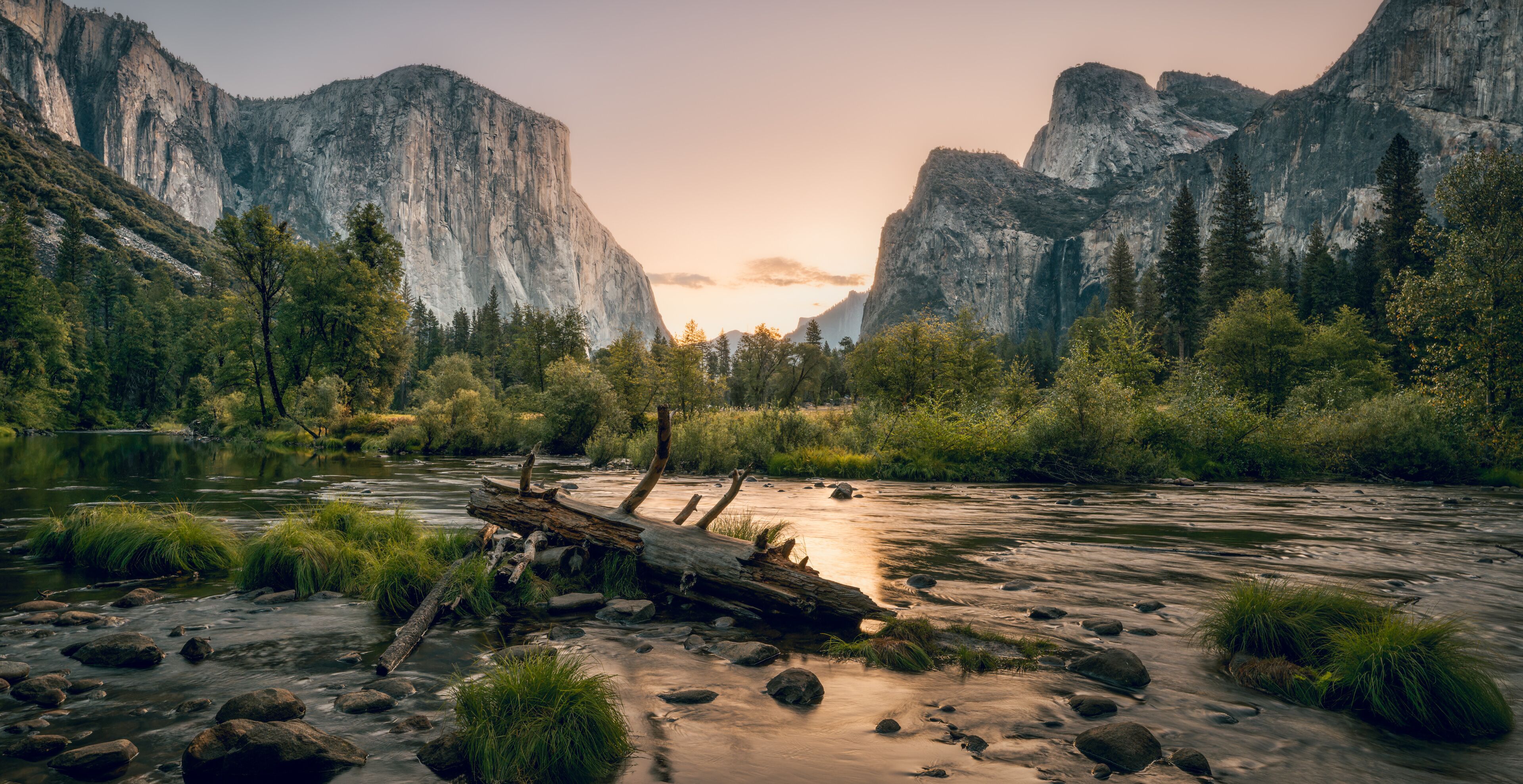 View of Yosemite Valley with Merced river in the foreground and granite massive of El Capitan and Cathedral Rocks in the background before sunrise. Yosemite National Park, California, USA  