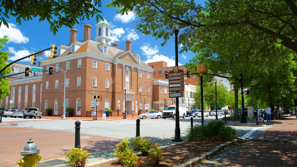 A historic brick building with a clock tower, a street sign, and a fire hydrant.