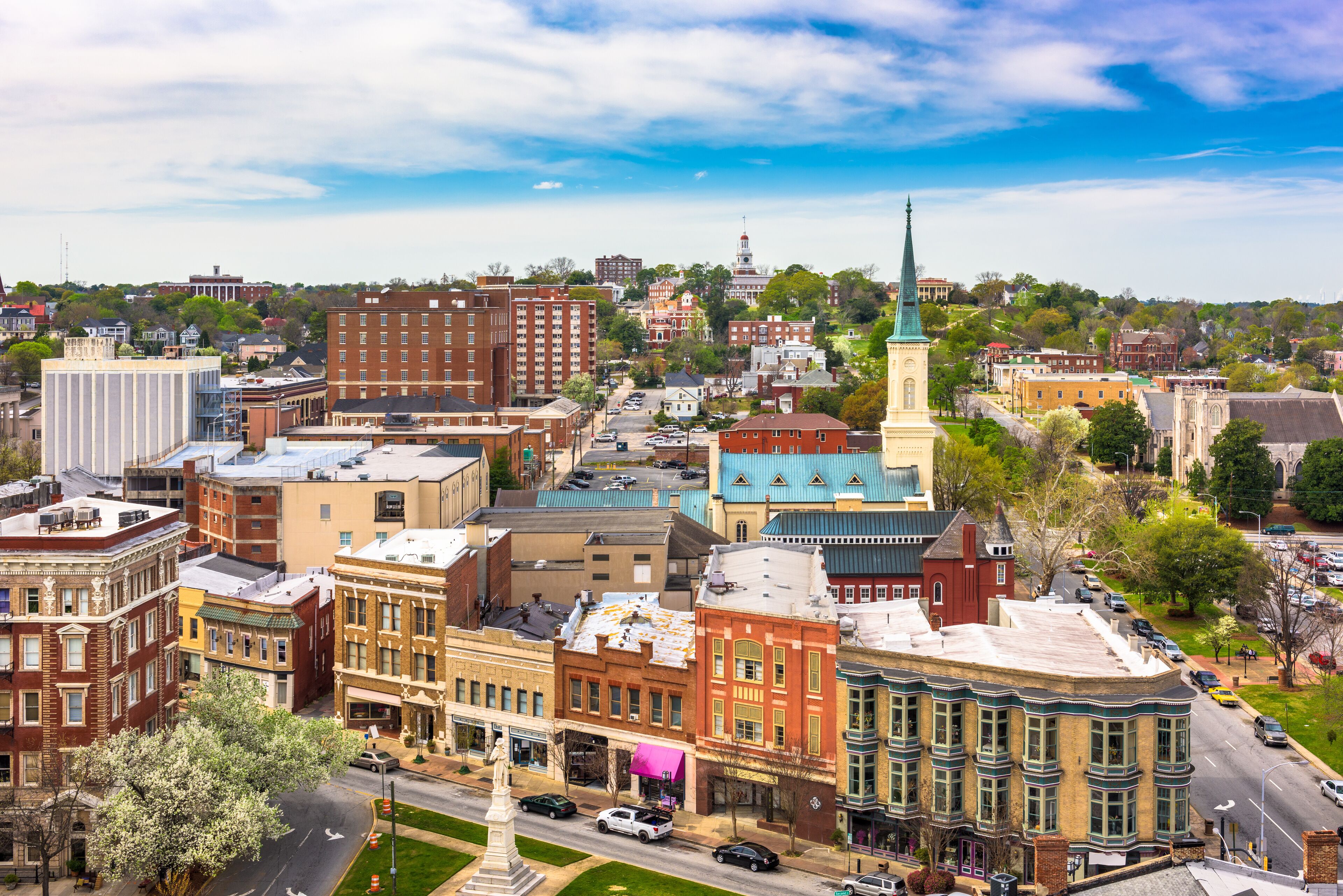 A historic town with a prominent church steeple, a variety of colorful buildings, and a well-maintained street.