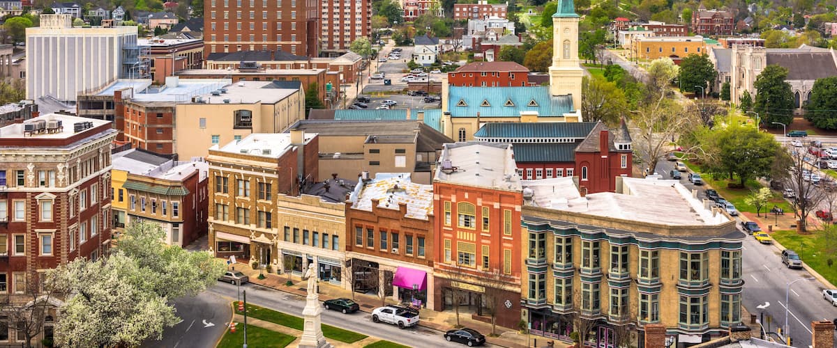 A historic town with a prominent church steeple, a variety of colorful buildings, and a well-maintained street.