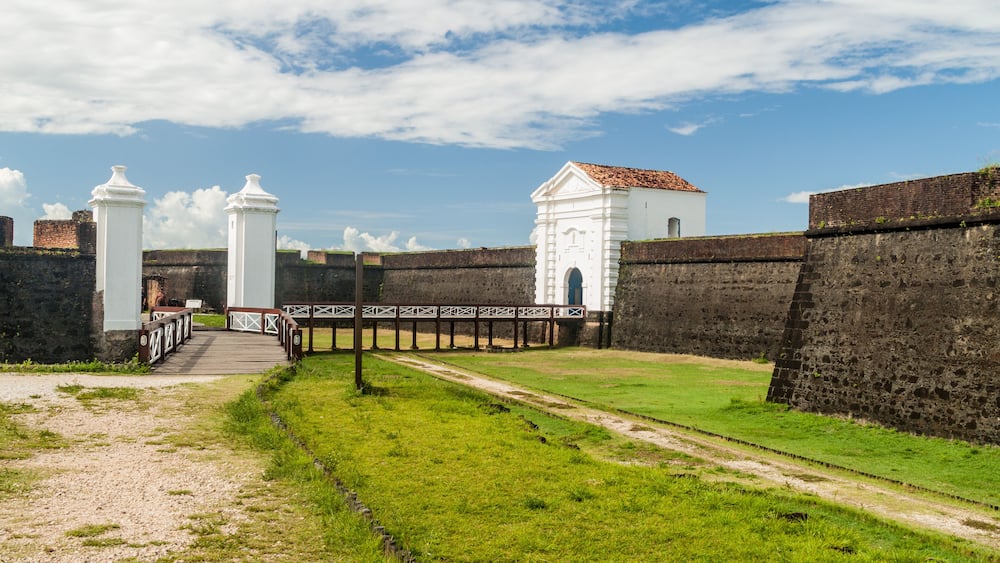 A historic fort with white towers and a brick wall.
