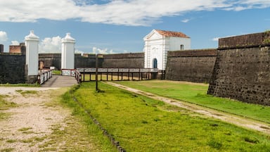 Una fortaleza histórica con torres blancas y un muro de ladrillo.