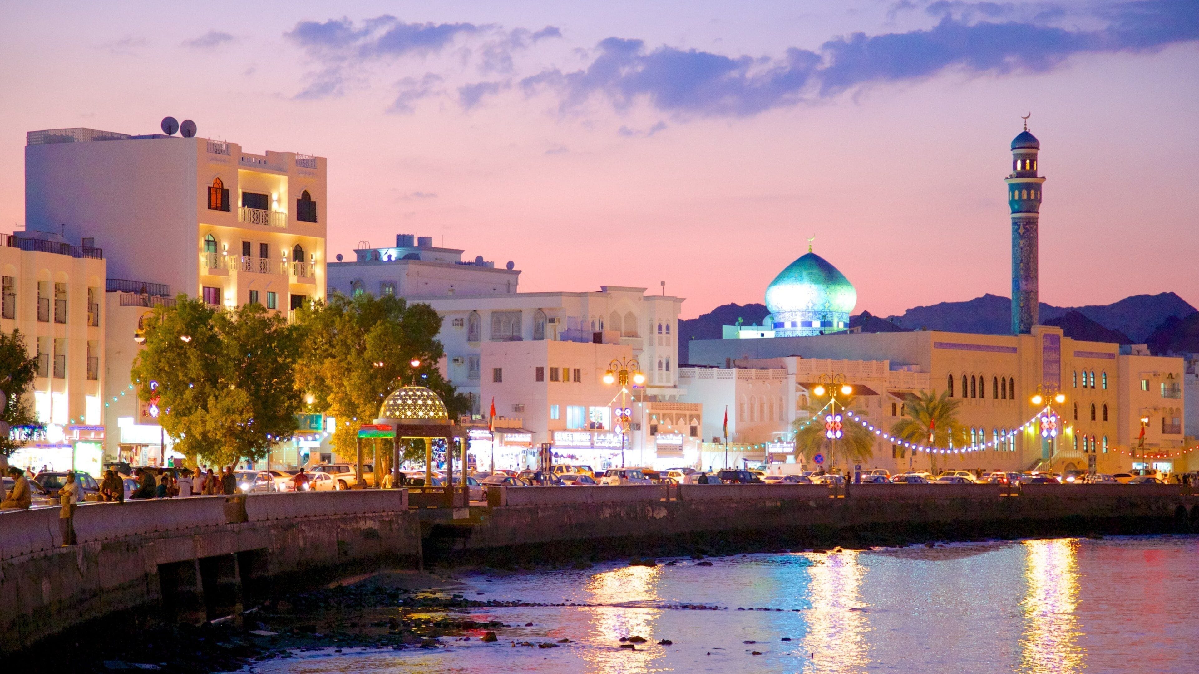 Muscat which includes a mosque, a bay or harbor and street scenes