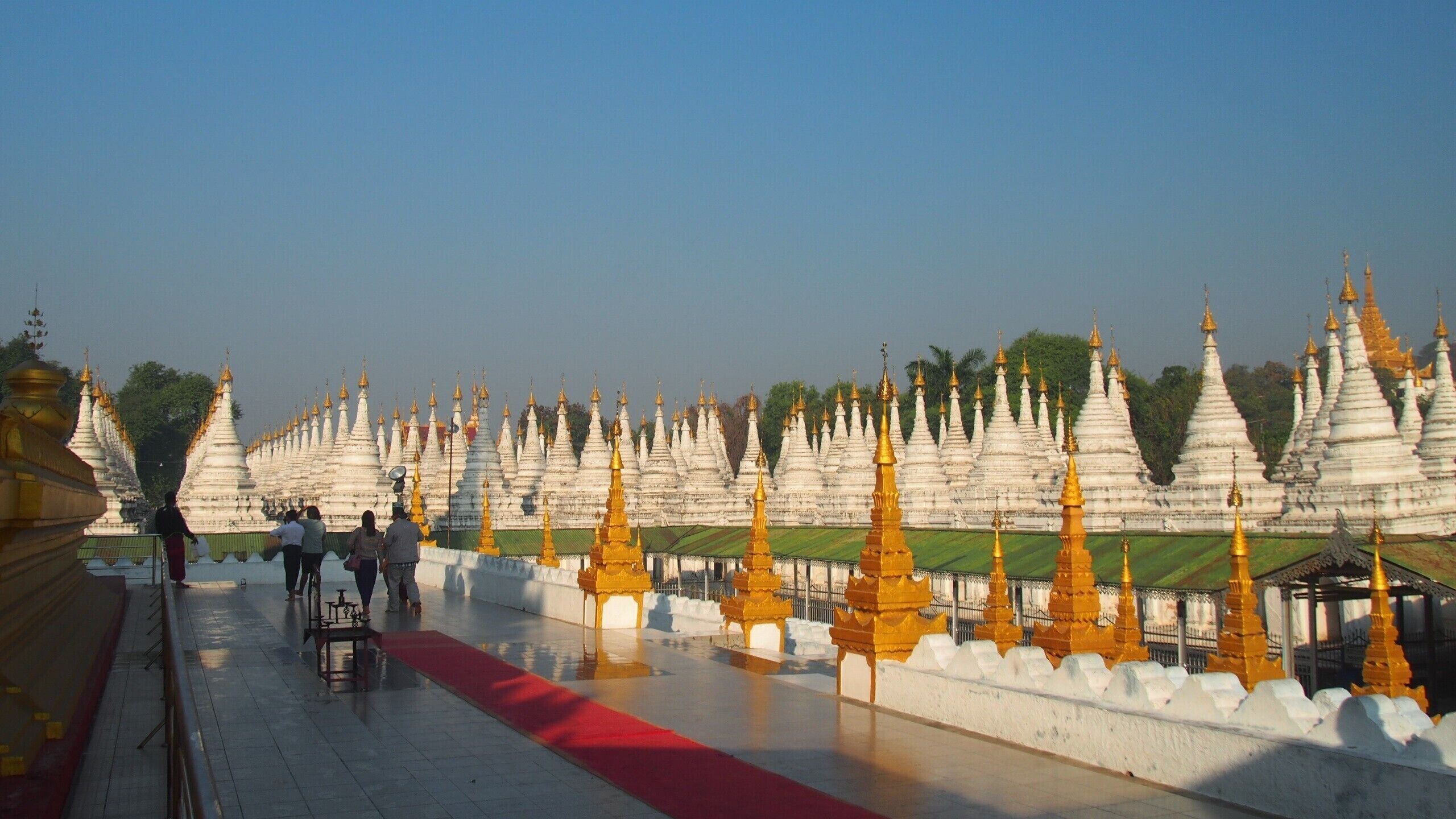 A temple complex with numerous white and golden spires.