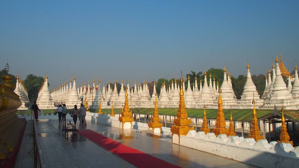 A temple complex with numerous white and golden spires.