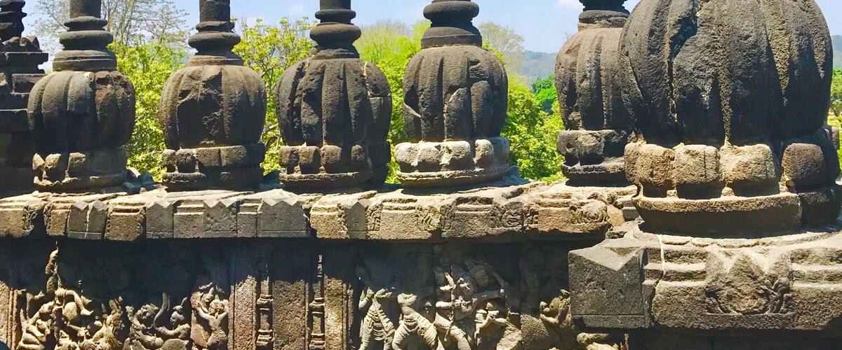 Stone structures with intricate carvings and a clear blue sky.