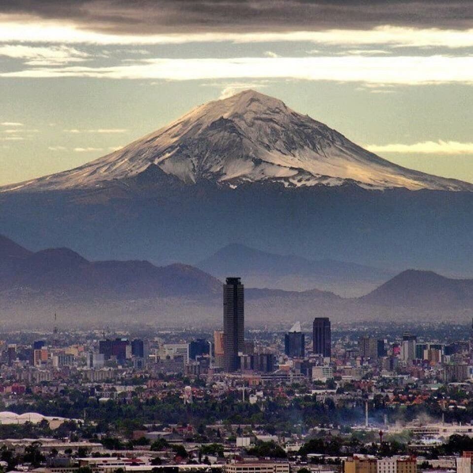 A cityscape with a prominent mountain in the background.