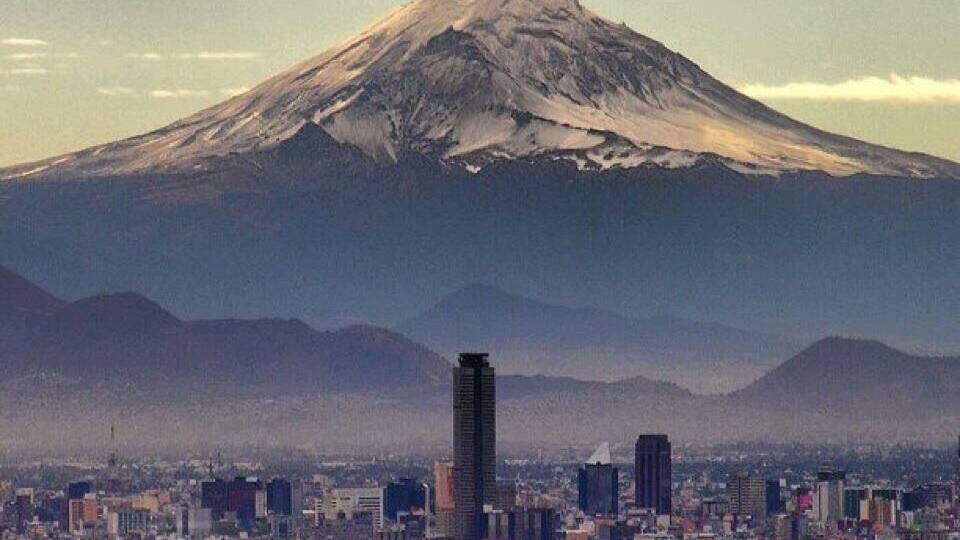 A cityscape with a prominent mountain in the background.