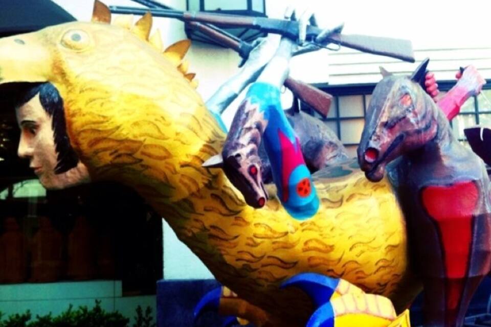 Uma escultura colorida de um cavalo e um cavaleiro.