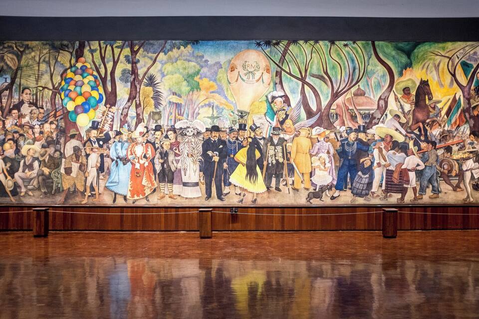 Um mural com uma multidão diversa em um cenário tropical, apresentando um balão de ar quente, palmeiras e um cavalo.