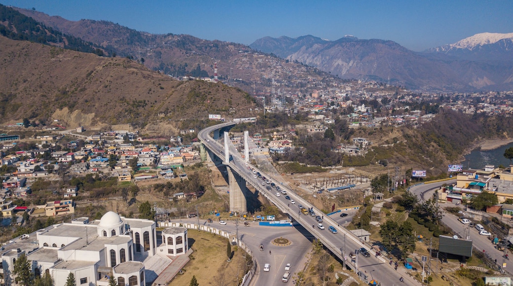 Aerial view of the earth quake memorial bridge spanning a river with mountains in the background, Muzaffarabad, Azad Jammu Kashmir, Pakistan.