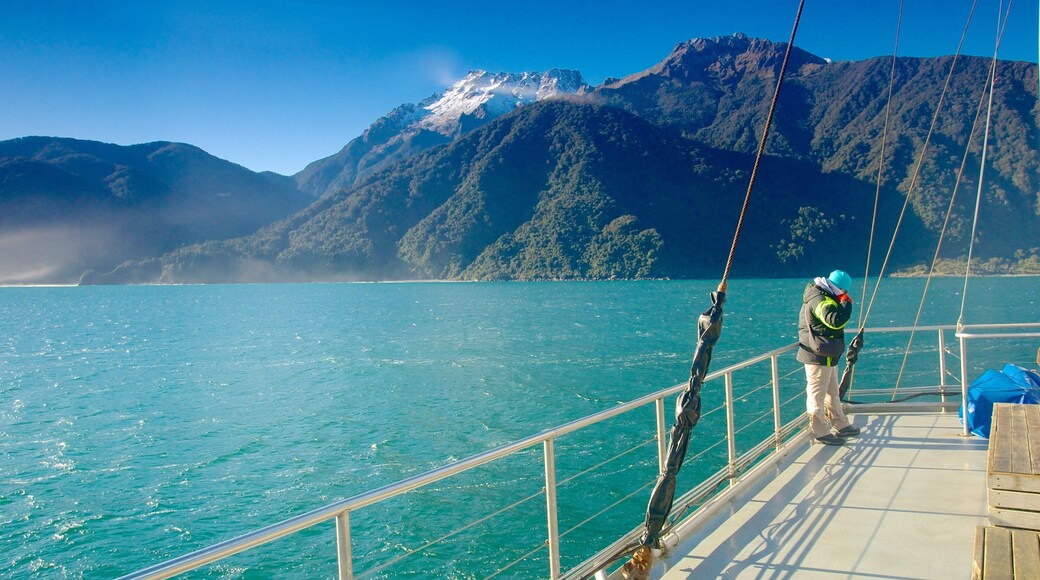 Milford Sound ofreciendo botes, un río o arroyo y montañas
