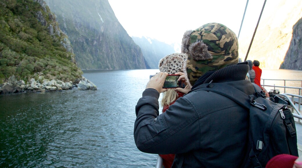 Milford Sound som viser bjerge, bådsejlads og en flod eller et vandløb