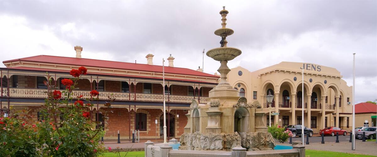 A historic building with a fountain and a well-maintained garden.