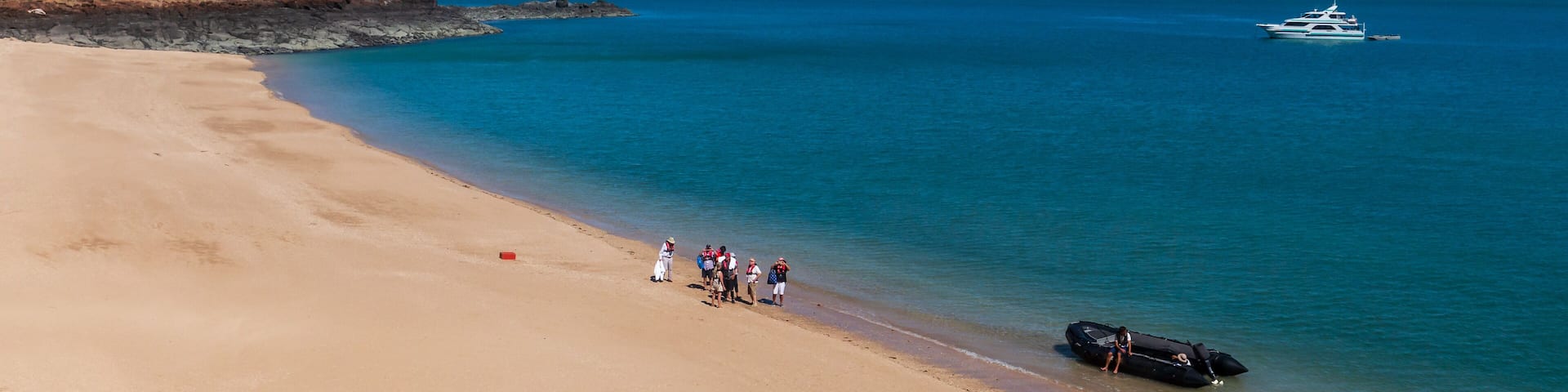 Tourists from a luxury expedition cruise ship explore a remote beach on Naturalist Island in the Kimberley before a sightseeing flight over Prince Frederick Harbour.