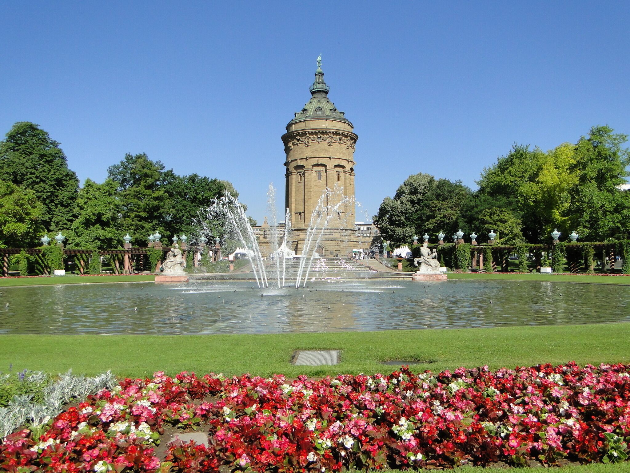 A historic tower with a fountain in a well-maintained garden.