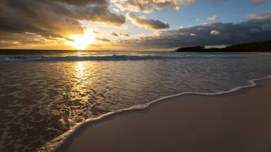 Waves sliding over the sand during sunrise in the Bahamas