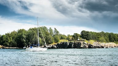 Small sailboat sailing against Finland shoreline
