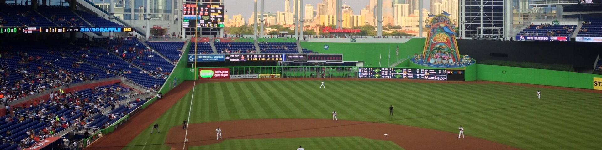 A baseball stadium with a city skyline in the background.