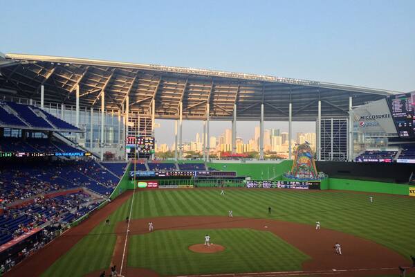 Un stade de baseball avec la silhouette de la ville en arrière-plan.