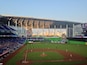 A baseball stadium with a city skyline in the background.
