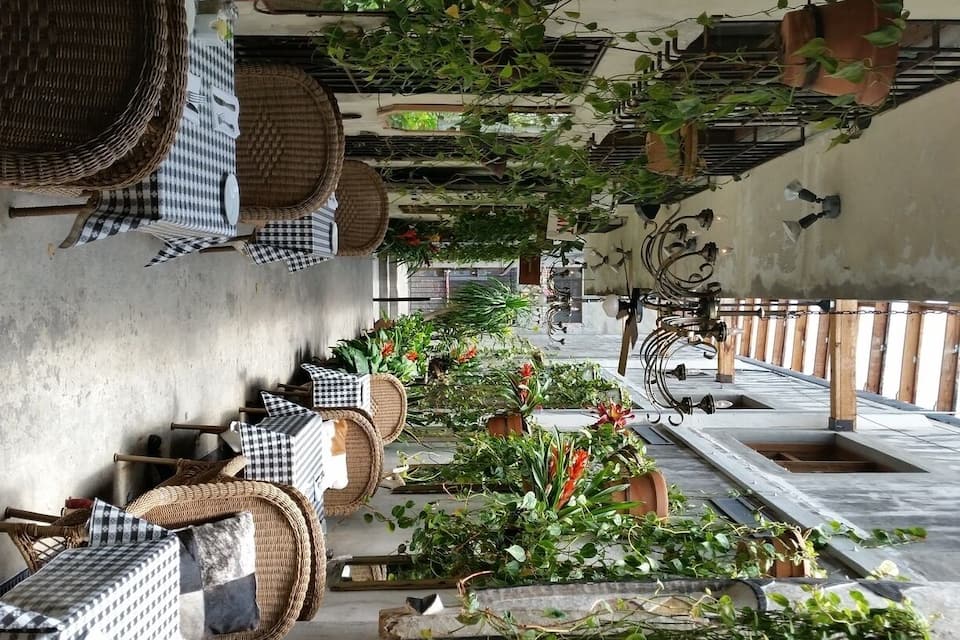 A rooftop garden with potted plants, wicker furniture, and hanging baskets.