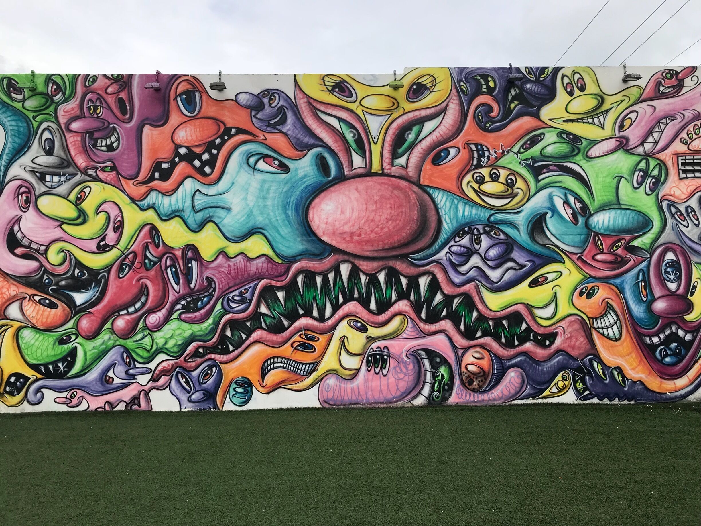A colorful mural with abstract faces and shapes.