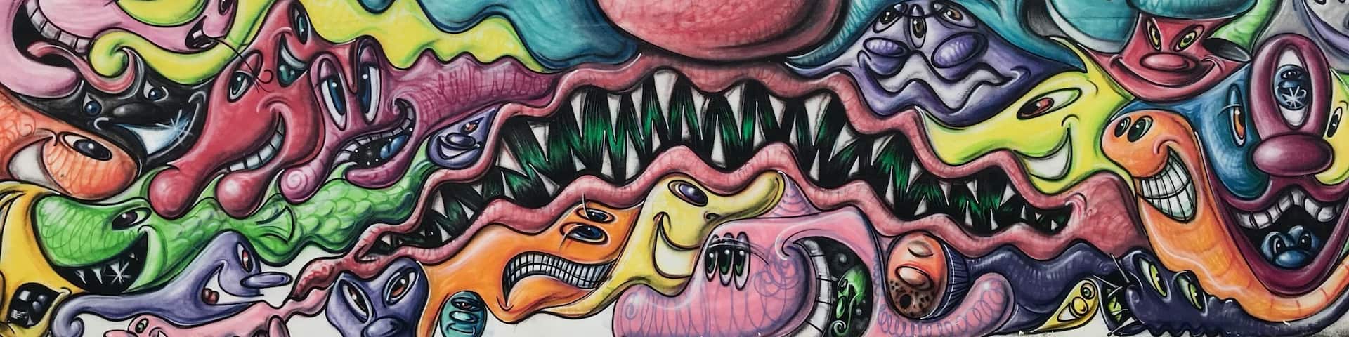 Un mural colorido con rostros y formas abstractas.