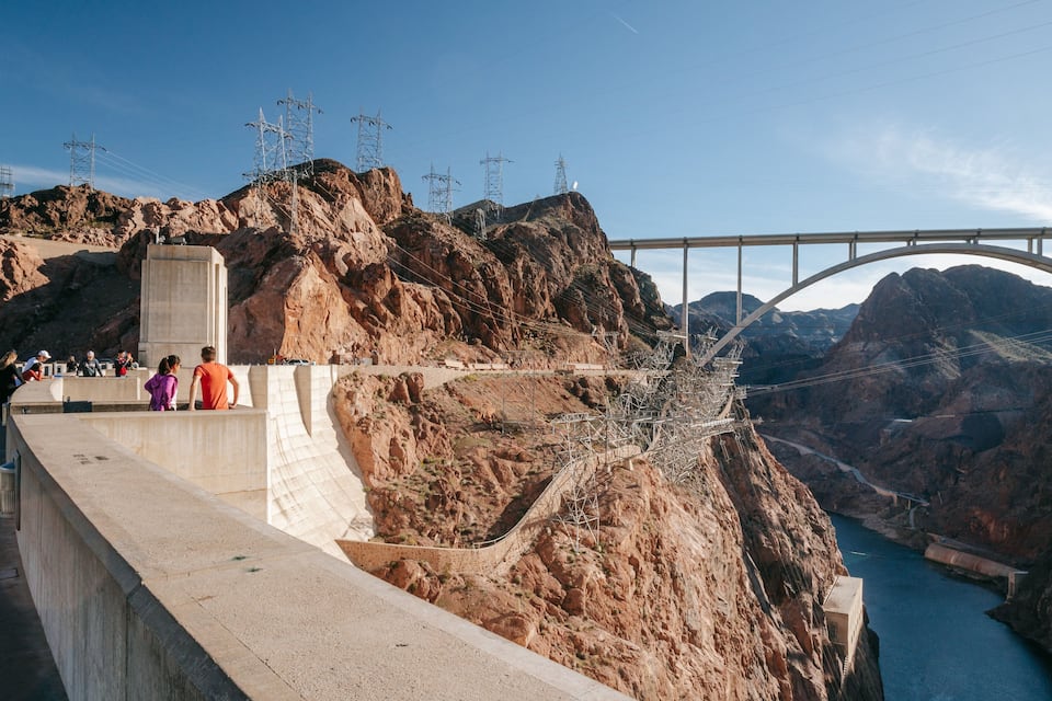 A bridge over a canyon with rocky cliffs and power lines.