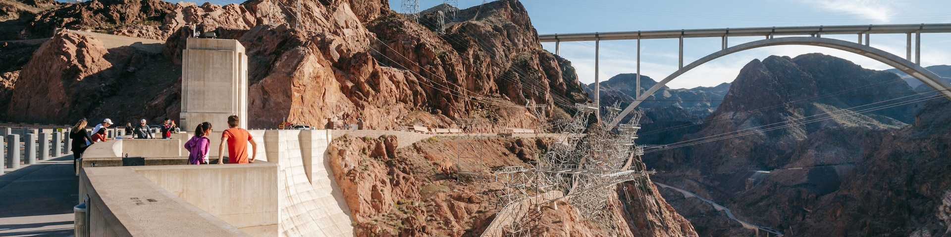 A bridge over a canyon with rocky cliffs and power lines.