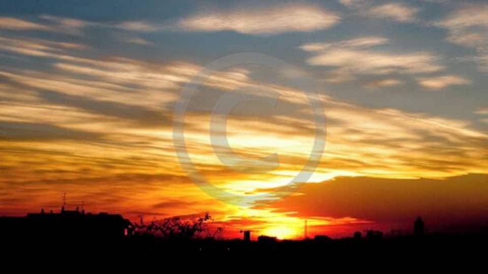 Ein Sonnenuntergang mit der Silhouette einer Stadtlandschaft.