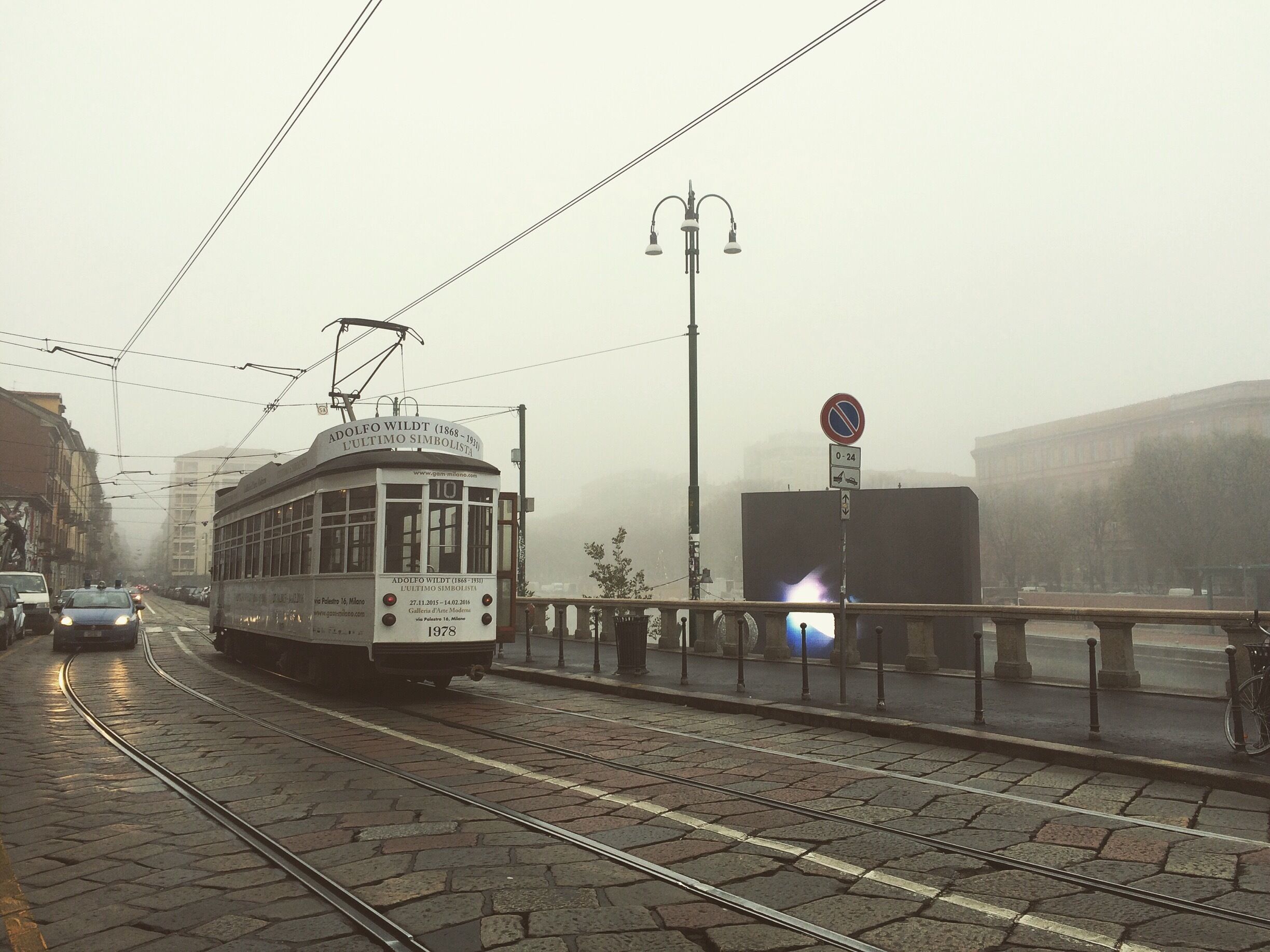 Foggy Navigli morning.  European trademark of car and tram co-existence. 