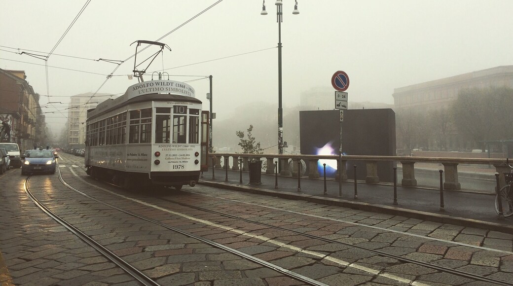 Foggy Navigli morning. European trademark of car and tram co-existence.