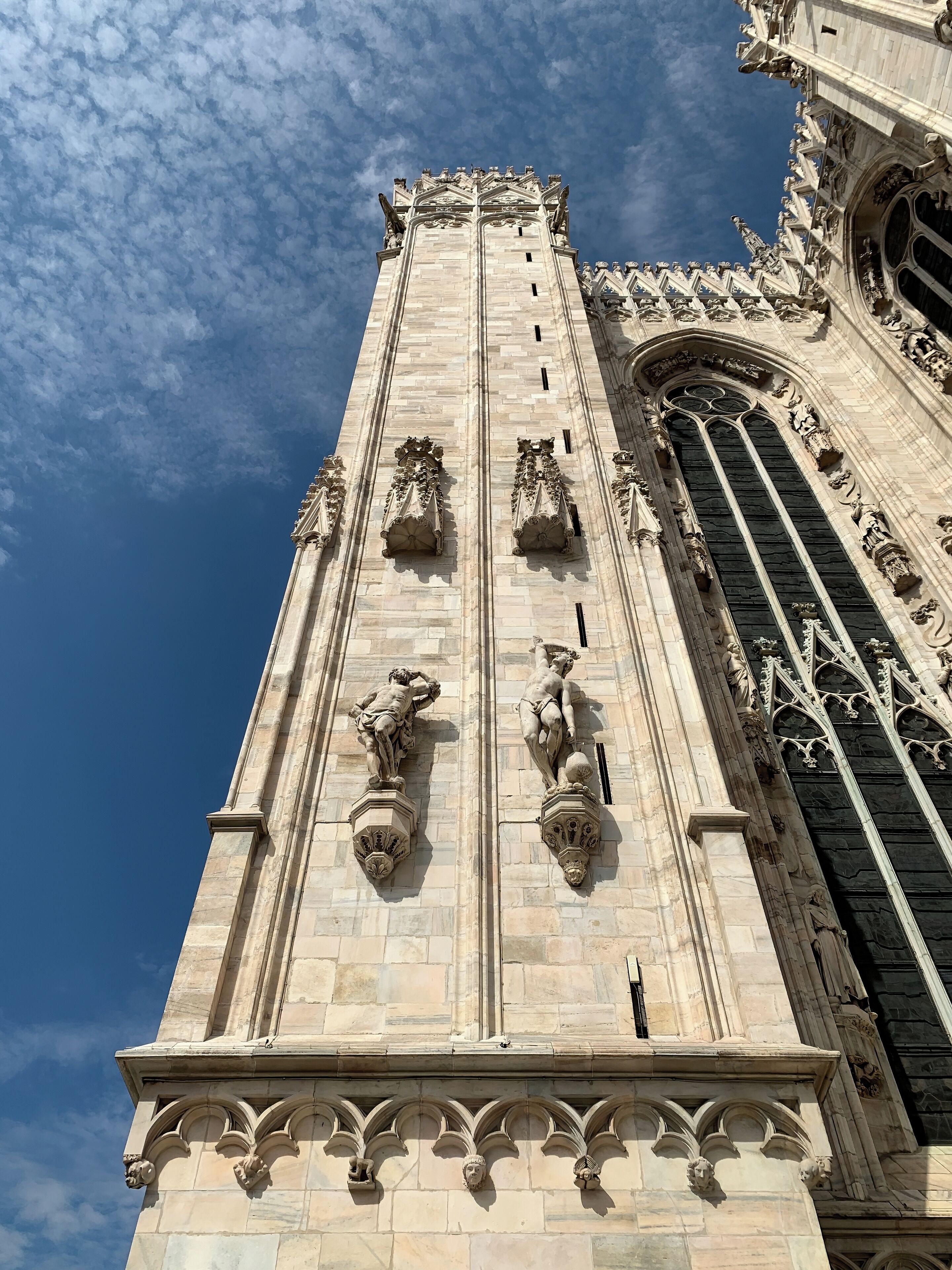 #Milan #Milano #Milão #Italy #Italia #Duomo

Milan Cathedral, better known as the Duomo, is one of the largest Gothic churches in the world. Its construction began in the 14th century and was not completed until about 500 years later. I had visited the cathedral twice but never climbed to its roof. On this last visit I had this privilege and the view you have is simply breathtaking: there are gargoyles, statues (around 3400) and 135 needles. The facade has several architectural styles including Gothic, Renaissance and Neoclassical. Also noteworthy are the bronze doors with bas-reliefs of city life and Our Lady. Inside, 52 huge columns support the entire structure. Among the statues of its interior I highlight that of Saint Bartholomew who is shown carrying his own skin.

A Catedral de Milão, mais conhecida como Duomo, é uma das maiores igrejas góticas do mundo. A sua construção foi iniciada no século XIV e só foi concluída cerca de 500 anos depois. Já tinha visitado a catedral duas vezes mas nunca tinha subido ao seu telhado. Nesta útima visita tive esse previlégio e a visão que se tem é simplesmente de tirar o fôlego: são gárgulas, estátuas (dizem que em torno de 3400) e 135 agulhas. A fachada possui vários estilos arquitetônicos entre eles o gótico, renascentista e neoclássico. Destaque também para as portas de bronze com baixos-relevos da vida da cidade e de Nossa Senhora. No seu interior 52 colunas enormes sustentam toda a estrutura. Entre as estátuas do seu interior destaque para a de São Bartolomeu que é mostrado carregando a sua própria pele.