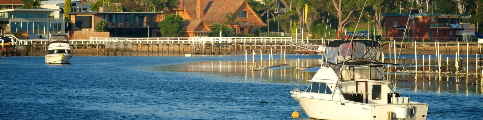 A coastal town with houses, a dock, and boats on the water.