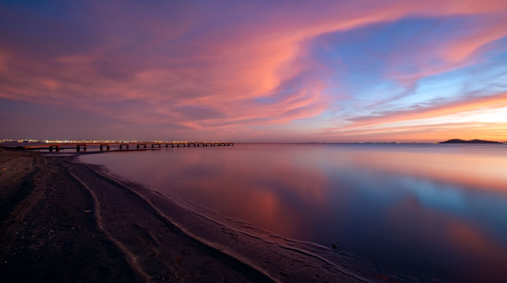 Idyllic pink and blue sunrise on the beach of Los Urrutias, in the Mar Menor, Cartagena, Region of Murcia, Spain with the clouds reflecting in the calm waters of the sea