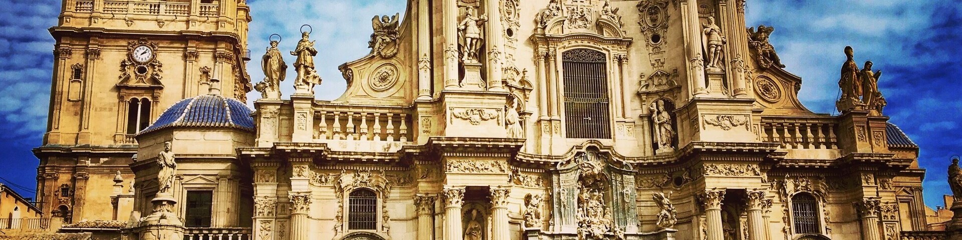 Eine historische Kathedrale mit aufwendiger Architektur und einer Menschenmenge vor der Fassade.