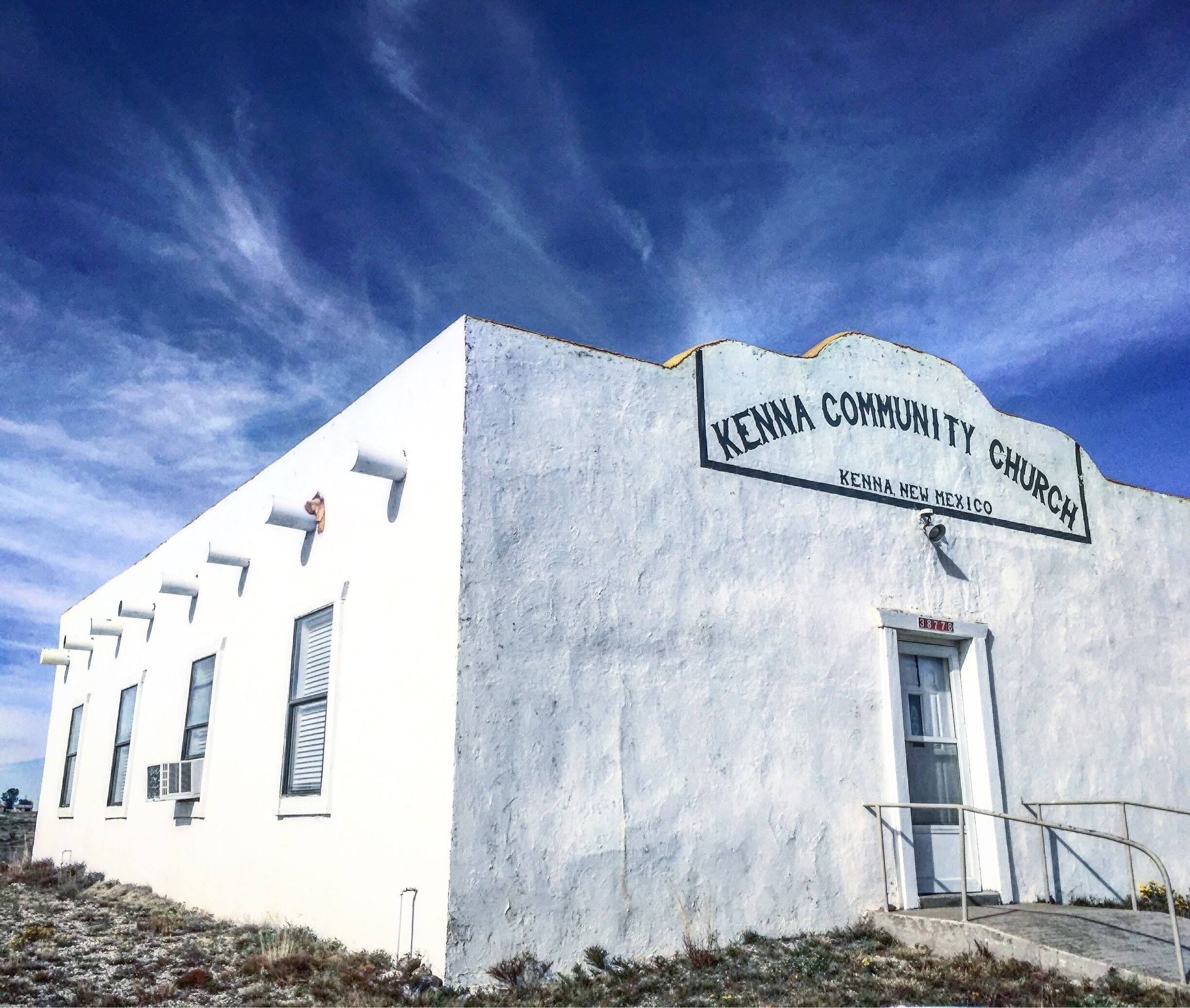 A white building with a sign reading "Kenna Community Church Kenna New Mexico".