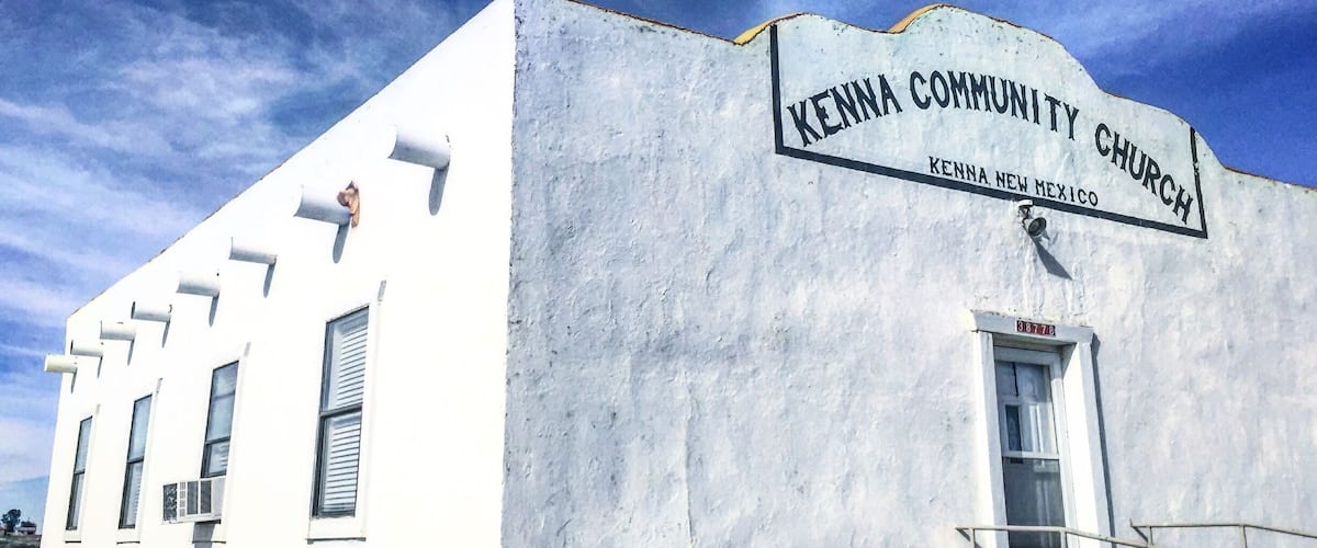 A white building with a sign reading "Kenna Community Church Kenna New Mexico".