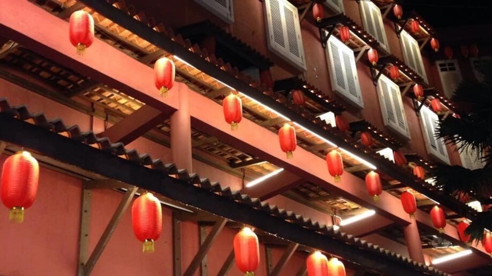 A traditional building with red lanterns and wooden beams.