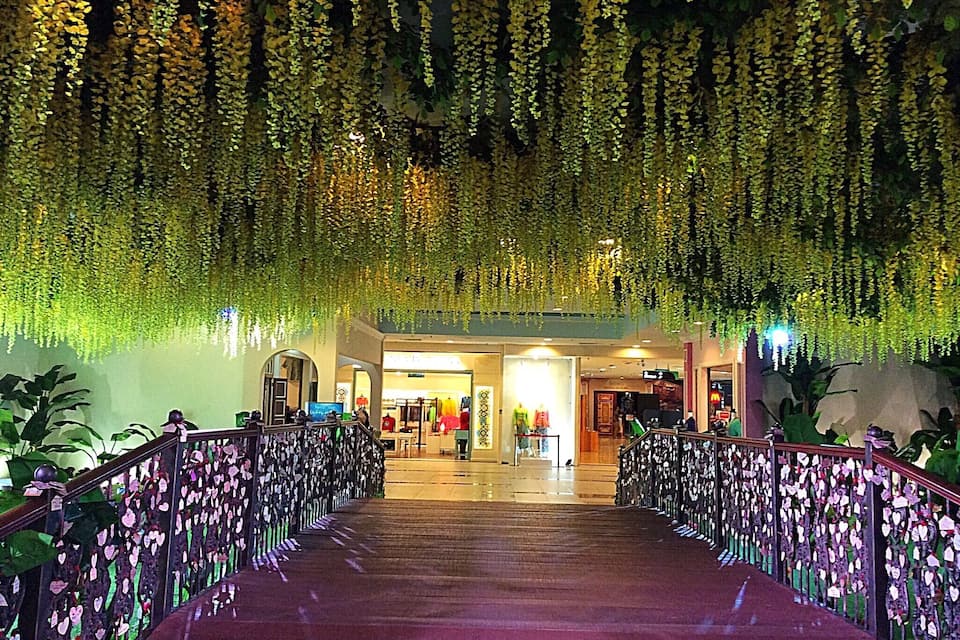 A covered walkway with hanging plants and heart-shaped decorations.