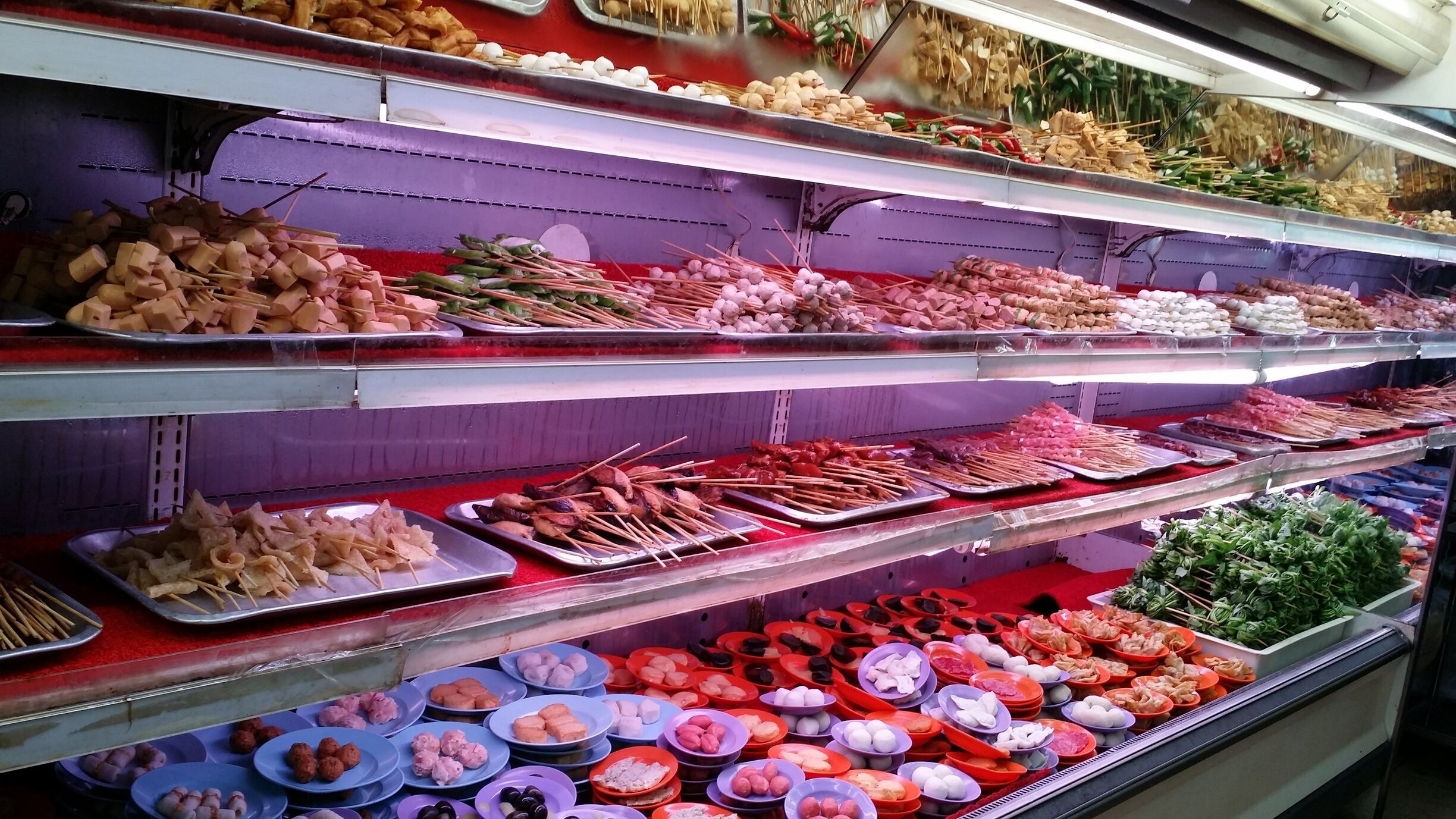 A variety of food items displayed on shelves in a market.