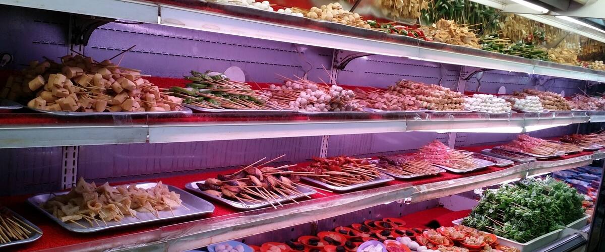 A variety of food items displayed on shelves in a market.