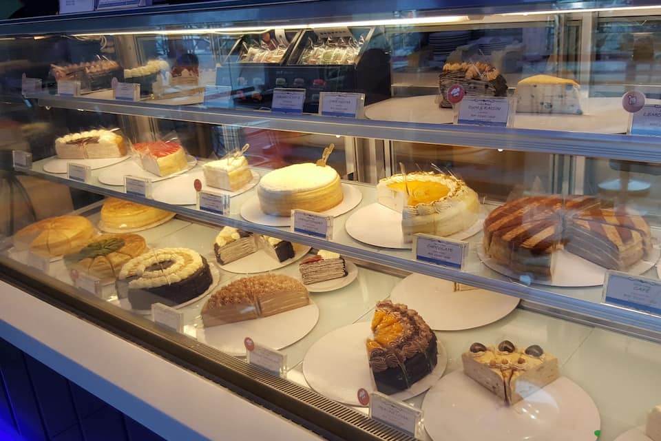 A bakery display case with various cakes and pastries.