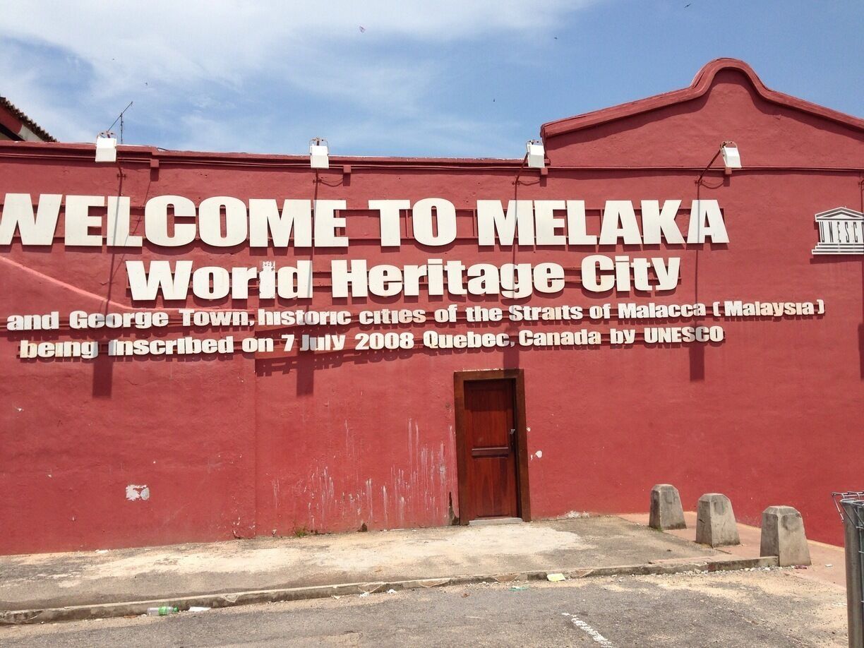 One of the red houses displaying it's welcome and inscription of heritage site city.