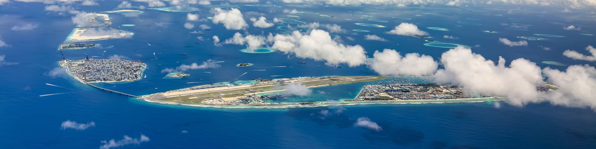 panoramic aerial landscape view of Malé City, the capital of Maldives with Sinamale Bridge as connection to Hulhule Island - Gulhi Falhu and Thilafushi in the background