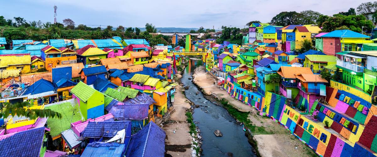 A densely packed village with colorful houses and a river running through it.
