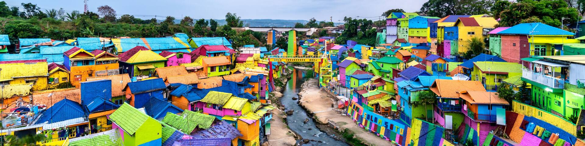 A densely packed village with colorful houses and a river running through it.