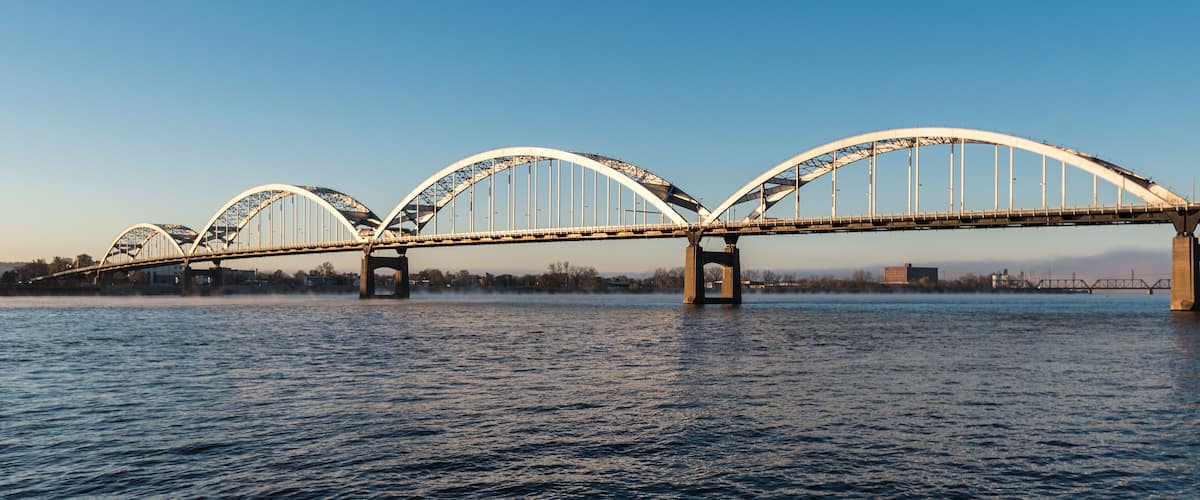 A large, arched bridge spanning a river with calm water.