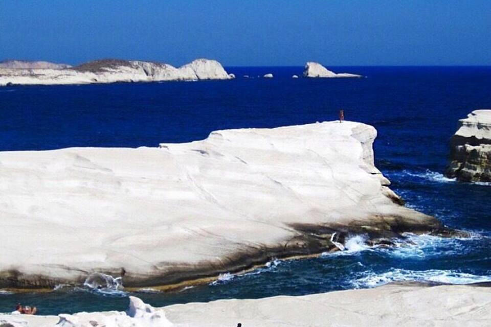 A coastal landscape with white cliffs and the ocean.